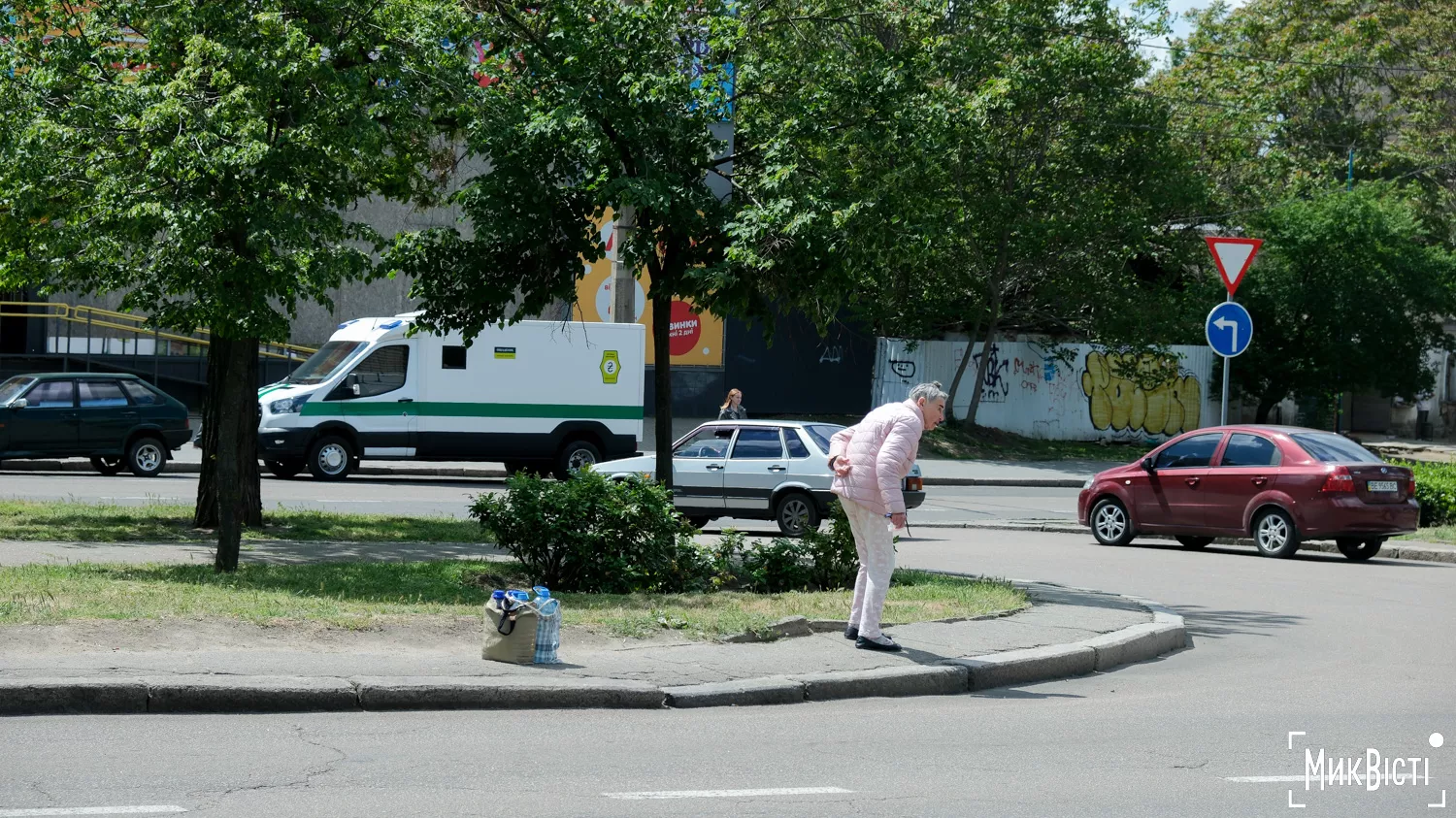 Літня жінка очікує на сусідку, яка допомагає їй набирати воду у точці видачі, травень 2025 року. Фото «NikVesti»